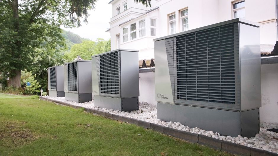 Moderný bytový dom s vonkajšou jednotkou tepelného čerpadla